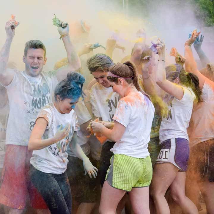 Students having fun in a cloud of brightly-colored powder at the Color Run
